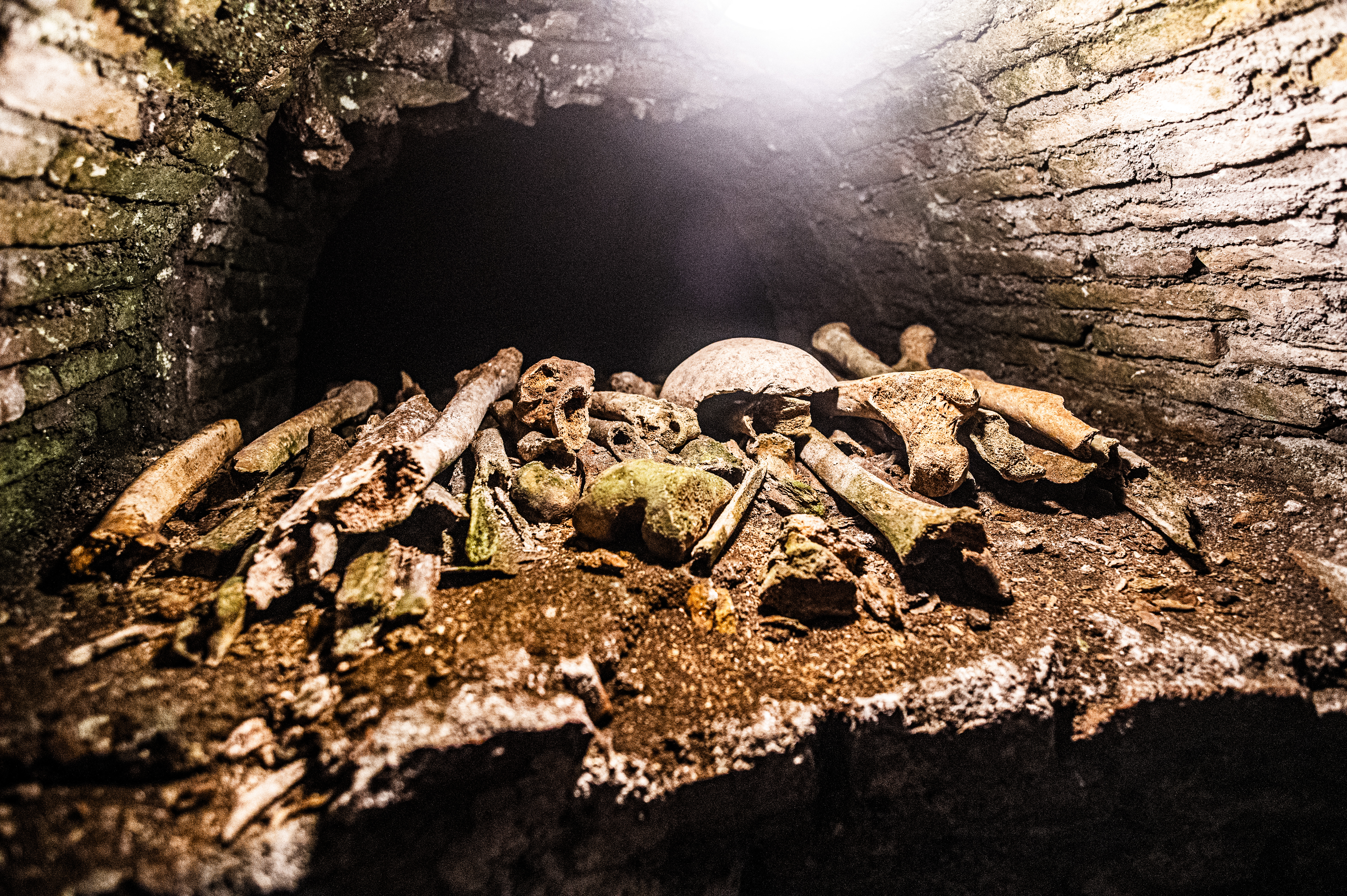 pile of human bones within a dark, confined space