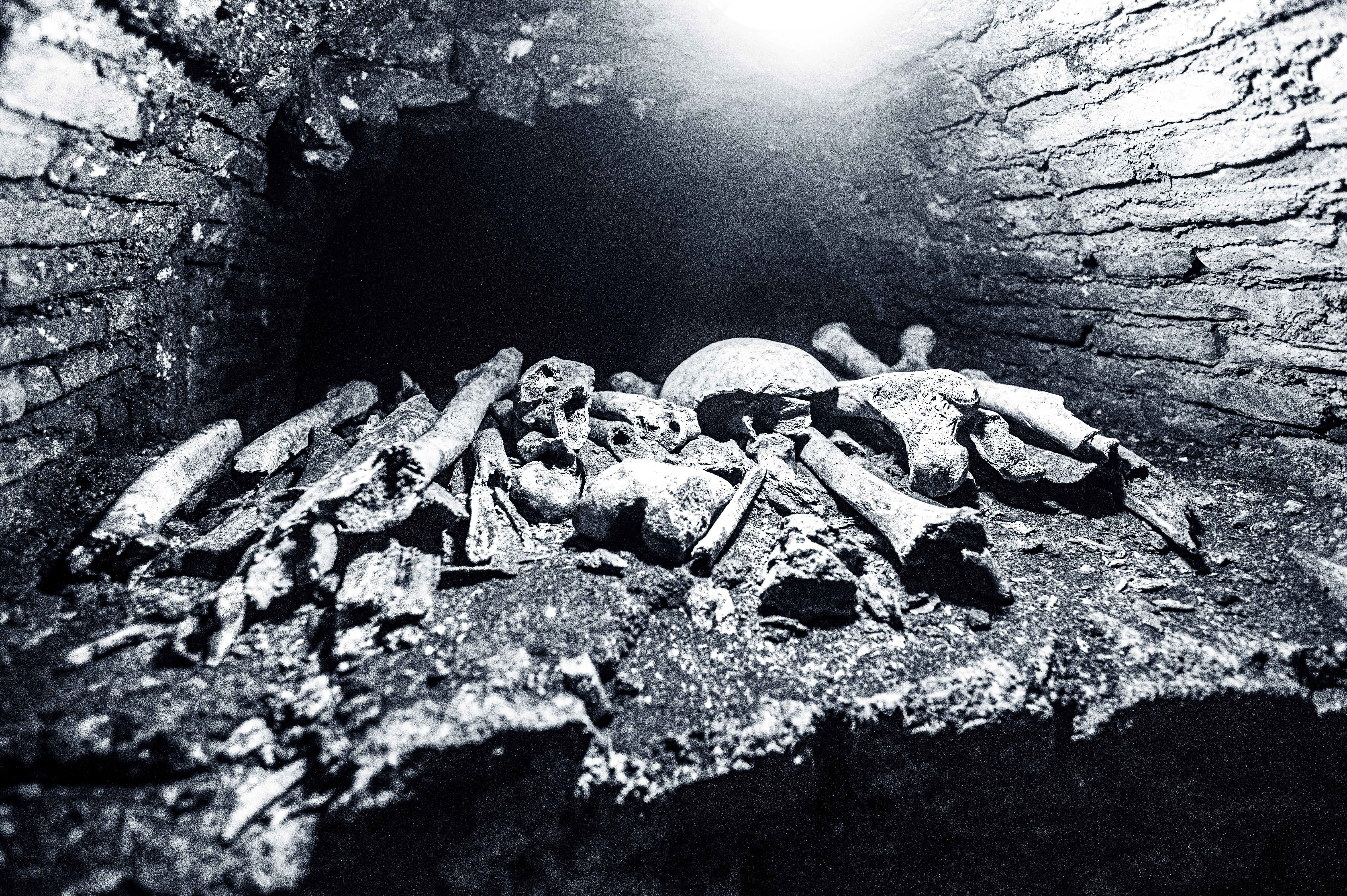 pile of human bones within a dark, confined space