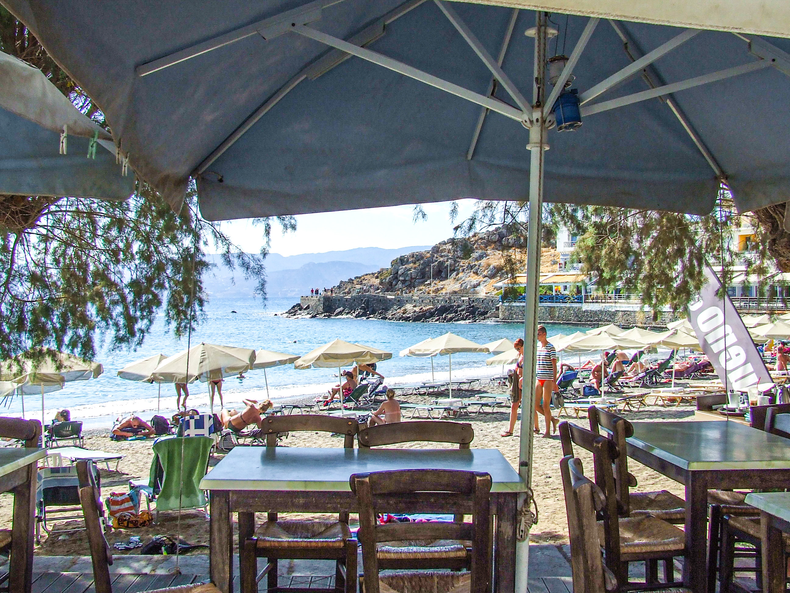 beach scene with people relaxing on sun loungers under umbrellas
