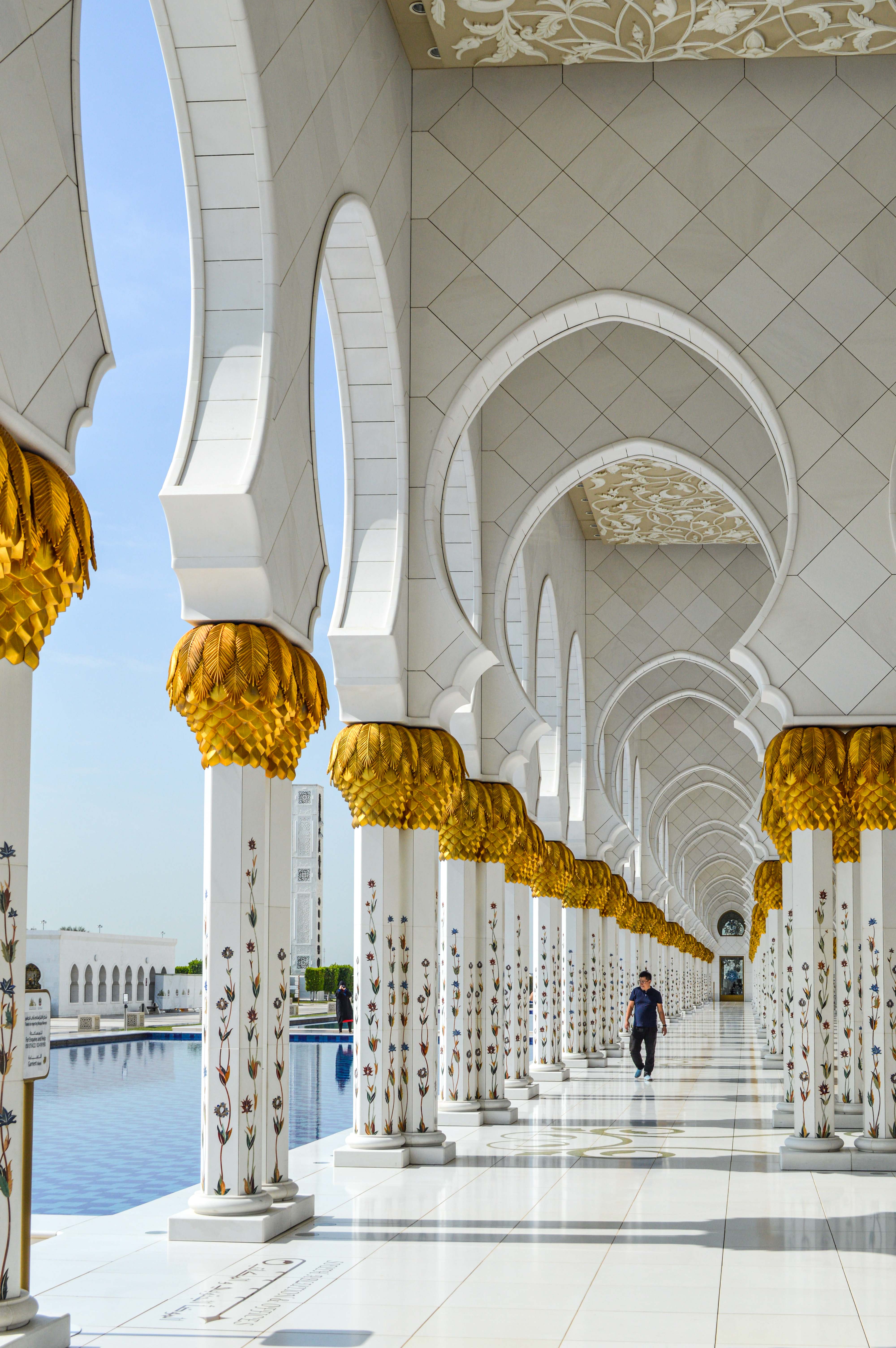 The arches are part of a large, open corridor that leads to a reflective pool